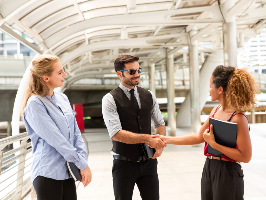 A sales representative with good body language shaking hands with a client.