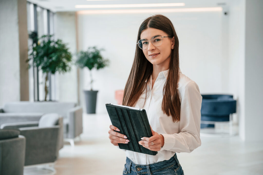 A confident young professional holding a tablet.