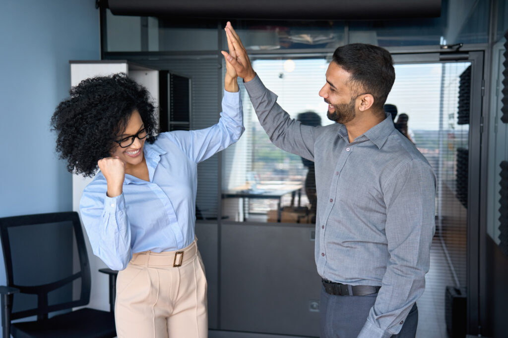 An employee with employer raising a high five because of her professional growth skills.
