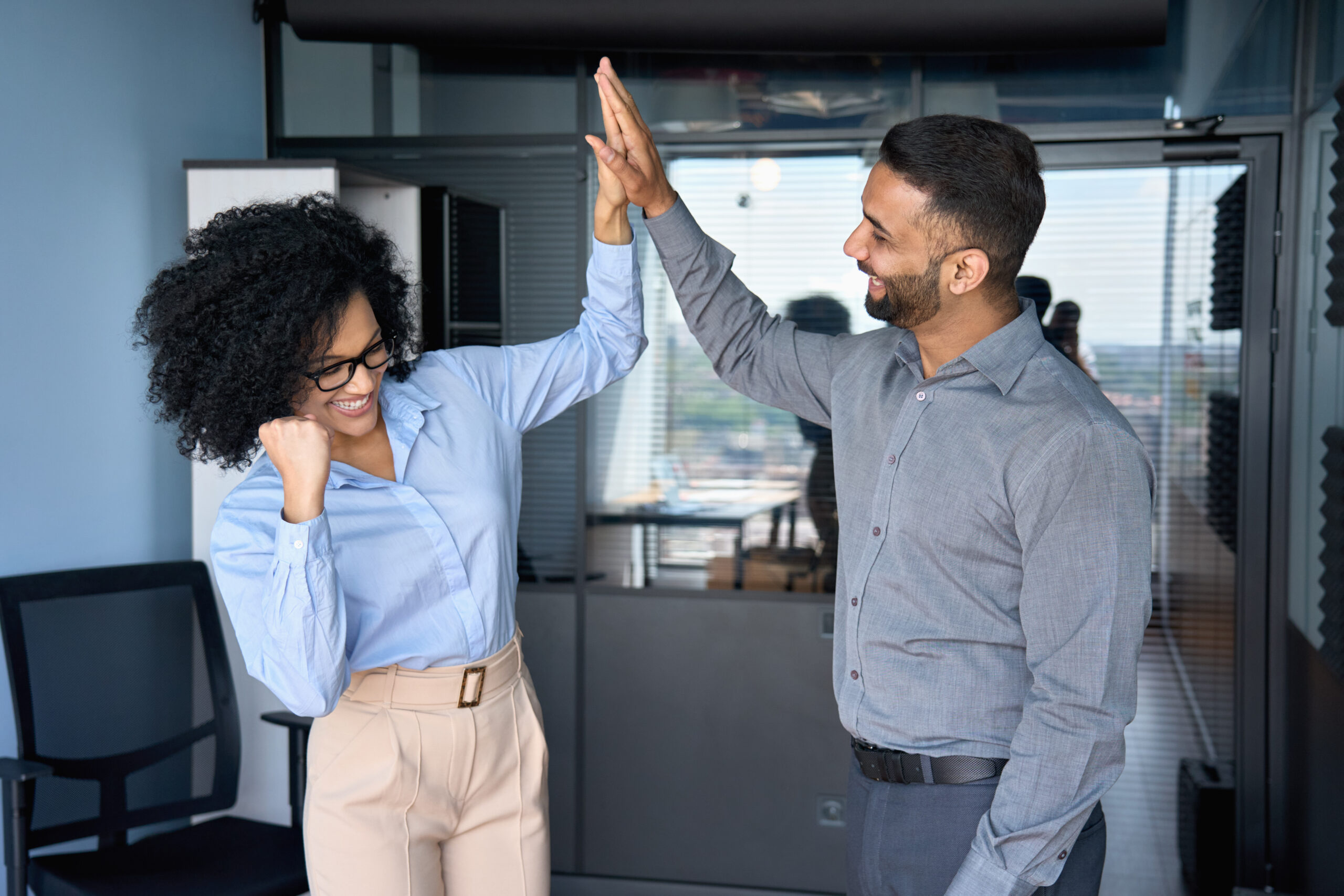 An employee with employer raising a high five because of her professional growth skills.